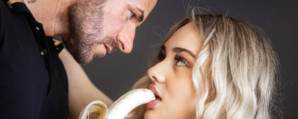Snake Dave nahe Aufnahme mit blonder Begleiterin im Studio-Setting mit Banane