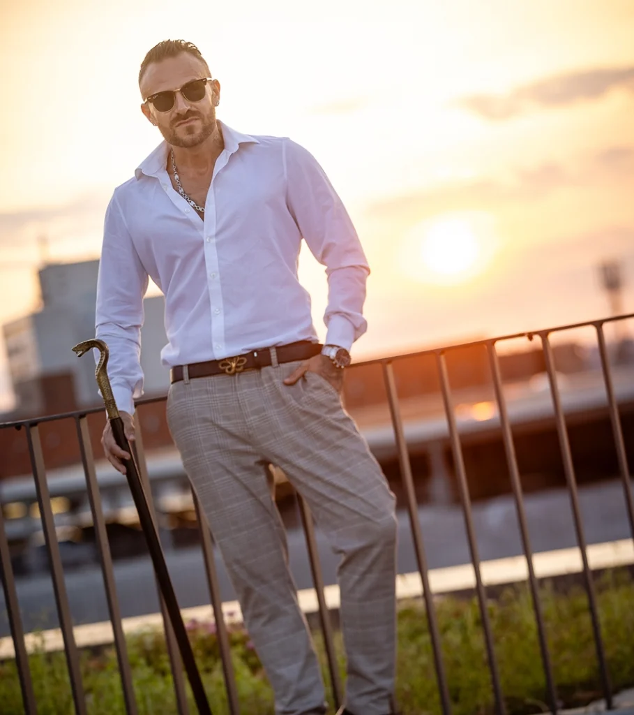 Snake Dave mit Sonnenbrille und weißem Hemd auf der Dachterrasse im goldenen Abendlicht